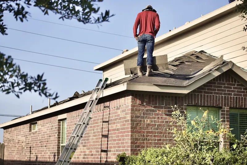 Professional roofer working on a residential roof in Kerman